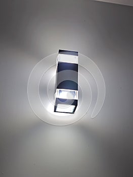 Modern wall lamp with minimalist rectangular design emitting soft white light