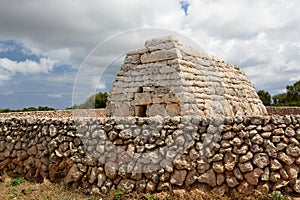 The modern wall surrounding the Naveta d\'Es Tudons, a megalithic chamber tomb. Menorca. Balearic islands. Spain