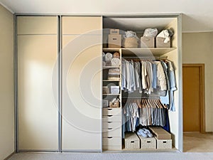 Modern wardrobe with stylish women's clothing. Concept of decluttering, organizing and tidiness