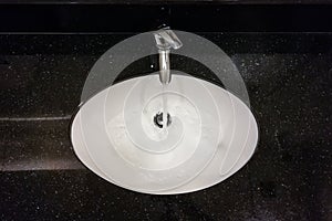 Modern wash basin with running water from tap faucet