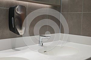 Modern wash hand basin with hands free sensor tap and hand dryer.