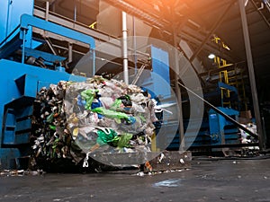 Modern waste sorting and recycling plant, hydraulic press makes wired bale from pressed PET bottles for processing and reuse of