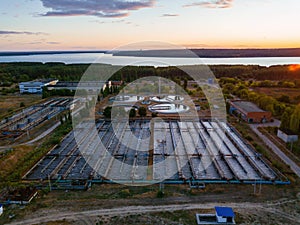 Modern wastewater treatment plant, tanks for biological purification of sewage, aerial view at the evening sunset