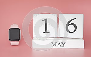 Modern Watch with cube calendar and date 16 may on pink background. Concept spring time vacation