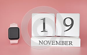 Modern Watch with cube calendar and date 19 november on pink background. Concept autumn time vacation