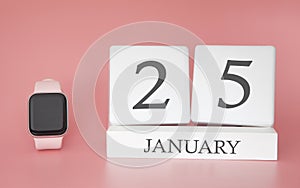 Modern Watch with cube calendar and date 25 january on pink background. Concept winter time vacation