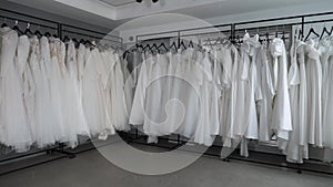 Modern wedding salon, lots of wedding dresses hanging on hangers.Wedding fashion