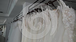 Modern wedding salon, lots of wedding dresses hanging on hangers.Wedding fashion