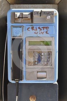 Modern well-worn payphone with grafittti