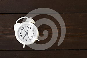 Modern white alarm clock on wooden background. Time is money mockup. Time-limit. Business deadline. Copy space