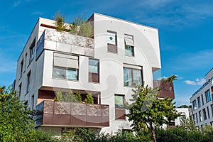 Modern white apartment house with metal balconies