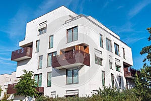 Modern white apartment house with metal balconies