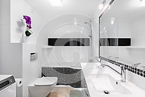 Modern white bathroom interior with black accents