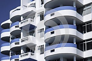 modern white building with blue accents and rounded balconies under a clear sky, showcasing unique architectural elements. ai