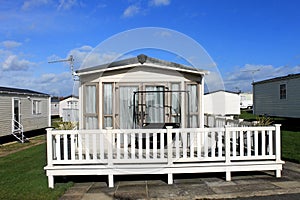 A modern white caravan on a trailer park.
