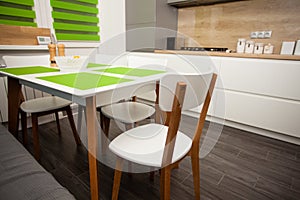 Modern white contemporary kitchen interior. Stylish dining table and chairs.