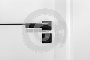 Modern white door with matte black handle and magnetic locks, bathroom door lock.