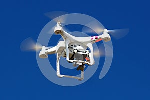 Modern white drone with four rotors and rotating camera
