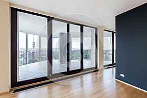 Modern white empty loft apartment interior with parquet floor with black column and panoramic windows, Overlooking the metropolis photo