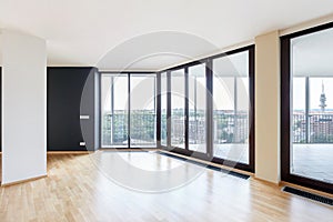 Modern white empty loft apartment interior with parquet floor with black column and panoramic windows, Overlooking the metropolis