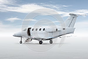Modern white executive airplane with an opened gangway door isolated on bright background with sky