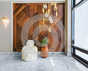 Modern white feather armless chair, tall wooden plant pot, decorated wood cladding wall, and big glass window