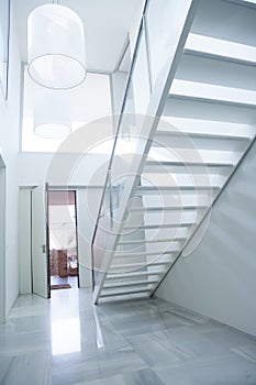 Modern white house entrance hall lobby with stairway