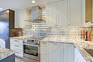 Modern white kitchen design with silver backsplash