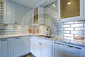 Modern white kitchen design with silver backsplash