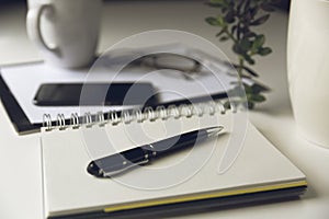 Modern white office desk table with smartphone and cup of coffee