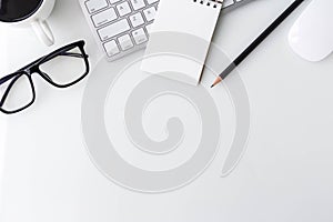 Modern white office desk top table with computer laptop, notebook and other supplies. Top view with copy space on white