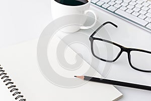 Modern white office desk top table with computer laptop, notebook and other supplies. Top view with copy space on white