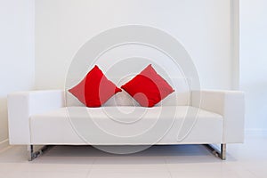 Modern white sofa with red pillows