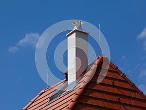 Modern white stucco finished chimney and bright brown red clay tile roof