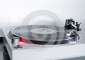 Modern white Turntable vinyl record player. Retro audio equipment for disc jockey. Sound technology for DJ to mix & play music.