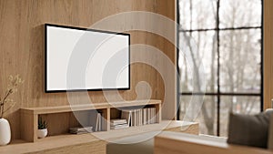 A modern white TV monitor mockup on a wooden wall in a modern, expensively furnished living room