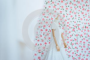 Modern white wedding dress on a mannequin with blured flower background