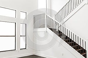 Modern white wooden staircase in new house interior with big windows