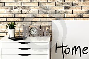 Modern wi-fi router on light commode near brick wall