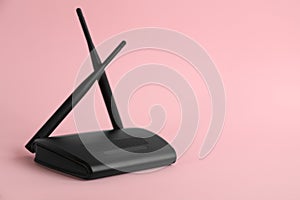 Modern Wi-Fi router on light pink background. Space for text