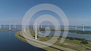 A Modern Wind Farm consisting of Wind Turbines with Two and Three Blades along the Shore of Veluwemeer under Partly Cloudy and