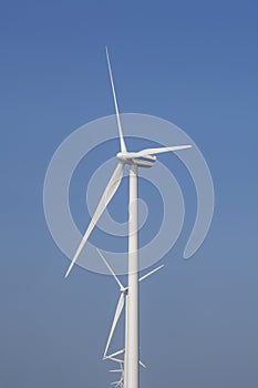 A Modern Wind Farm consisting of Wind Turbines with Two and Three Blades along the Shore of Veluwemeer under Partly Cloudy and