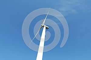 Modern wind turbine against blue sky, low angle view. Alternative energy source