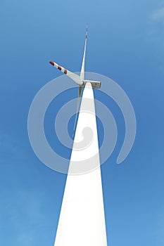 Modern wind turbine against blue sky, low angle view. Alternative energy source