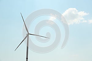 Modern wind turbine against blue sky, low angle view. Energy efficiency