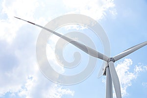 Modern wind turbine against blue sky, low angle view. Energy efficiency