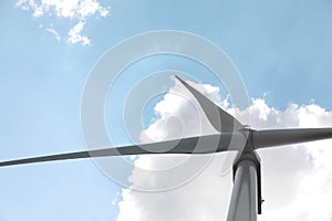 Modern wind turbine against blue sky, low angle view. Energy efficiency