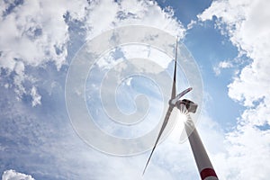 Modern wind turbine against sky, low angle view. Alternative energy source