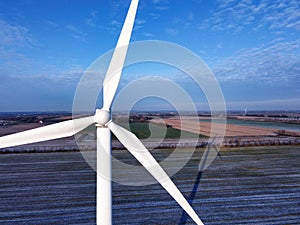 Modern wind turbine stands in the middle of a rural landscape