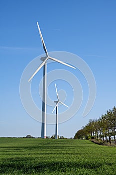 Modern wind turbines in front of a blue sky